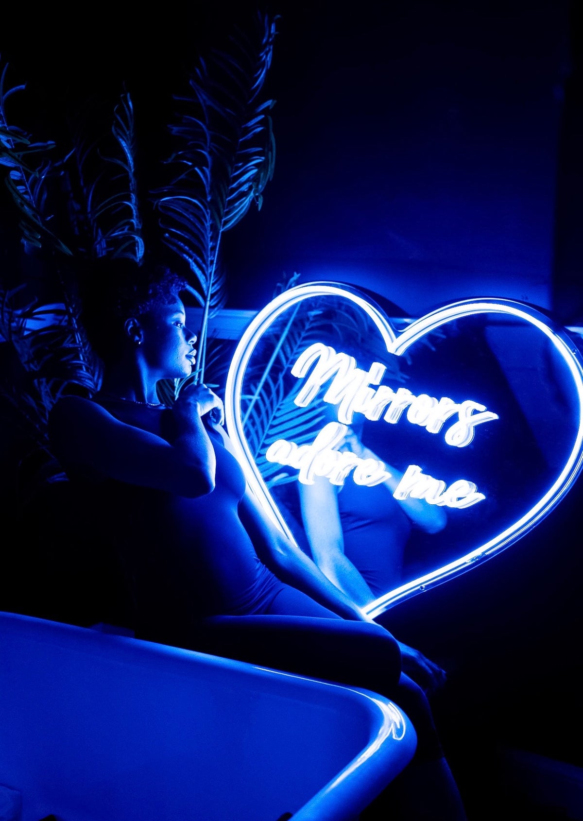 Blue custom LED neon heart sign glowing in a dark room